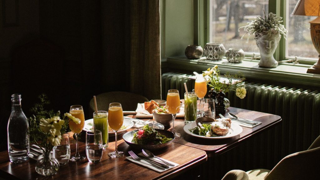 Ett uppdukat bord på Åkeshofs Slott med olika brunchrätter och dryck som juce.